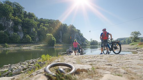 Radler an der Donaufähre bei Weltenburg Zwei Radler mit Fahrrädern stehen am Ufer der Donau und warten auf die Fähre, die sie ans andere Ufer bringen wird.